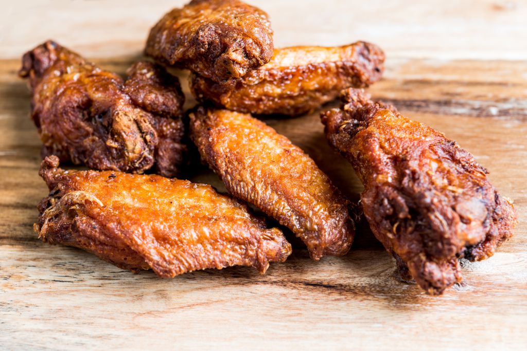 Close-Up Of Chicken Wings On Wooden Board