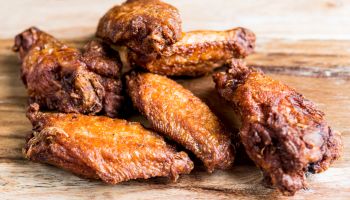 Close-Up Of Chicken Wings On Wooden Board