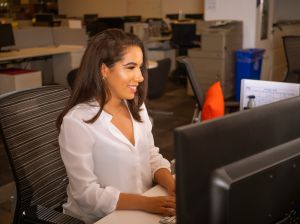 Latino Woman At Desk Smiling