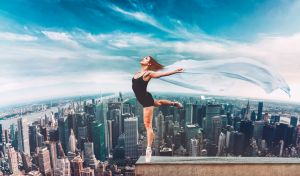 Ballet dancer stand on the edge on roof top above New York City